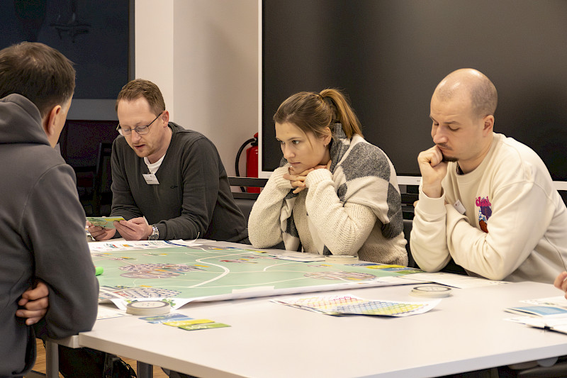Wie geht es weiter? Vier Spielerinnen und Spieler sitzen konzentriert am Mobiland-Spielplan. Foto: Franke/LNVG