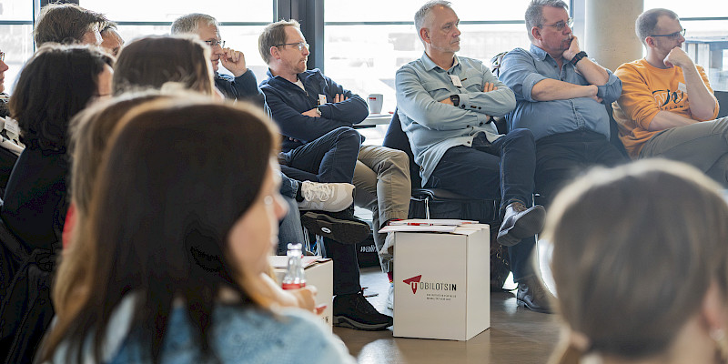 Interessierte Personengruppe vor einem Whiteboard