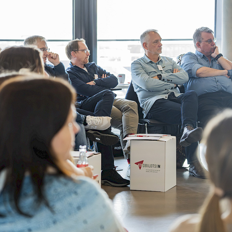Interessierte Personengruppe vor einem Whiteboard
