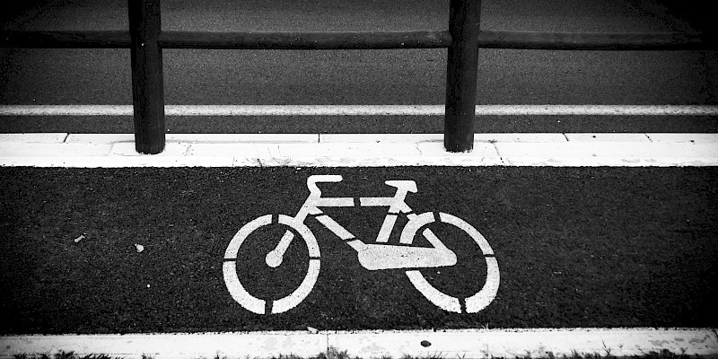 Das Bild zeigt ein großes Fahrradoiktogramm. das Bild ist in Schwarz weiß gehalten.