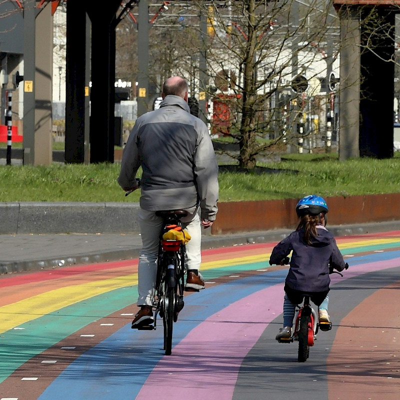 Das Bild zeigt eine Comic-Darstellung der EMW-Maskottchen Edgar und Edda, die mit Fahrrad, Rollator und Langstock unterweg sind. Oben im Bild ist der Schriftzug 