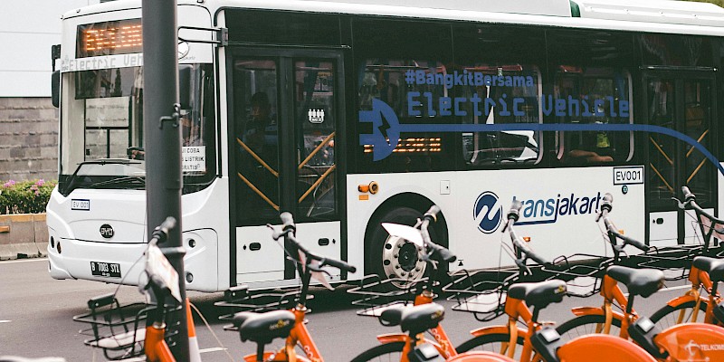 Auf dem Bild ist ein Bus zu sehen, vor dem Bus sind mehrere Leihfahrräder zu sehen.