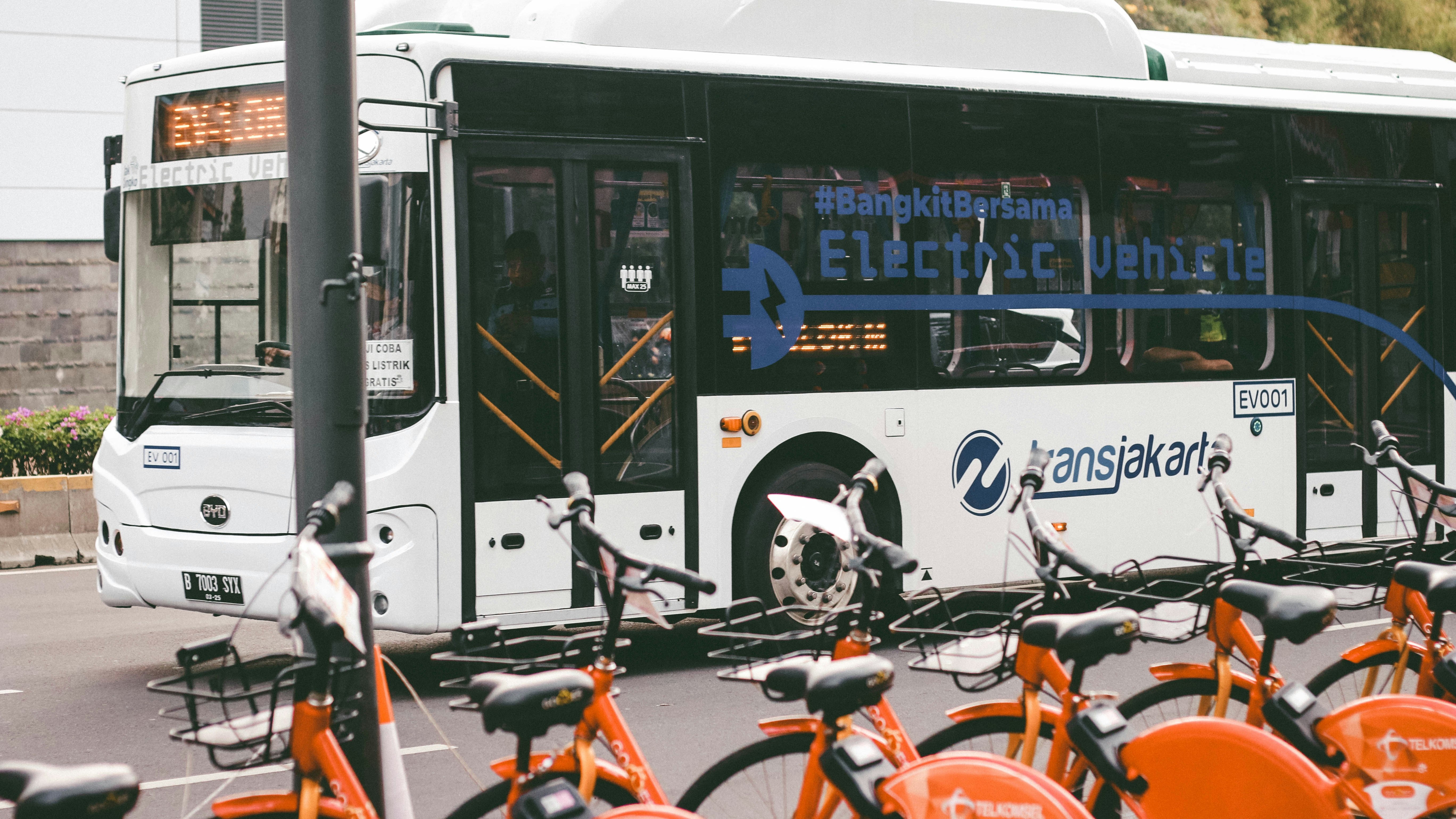 Auf dem Bild ist ein Bus zu sehen, vor dem Bus sind mehrere Leihfahrräder zu sehen.